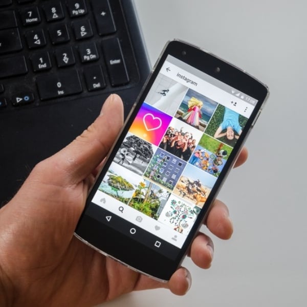 mano sosteniendo celular con interfaz de Instagram