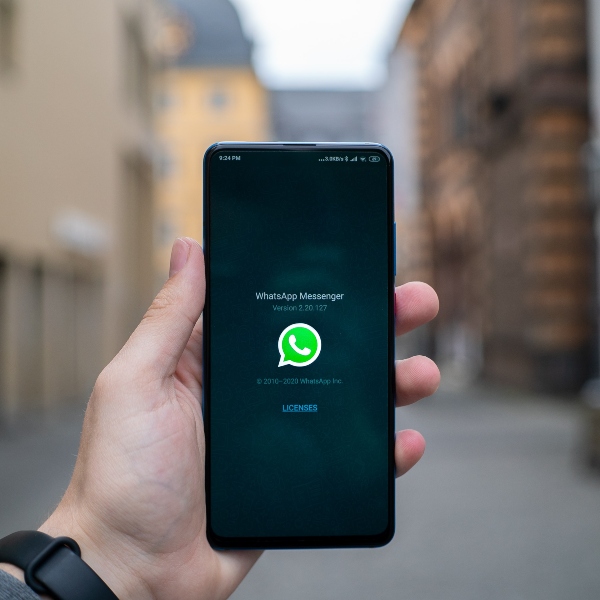 Teléfono en mano con pantalla de Whatsapp 