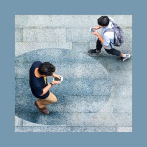 jovenes mirando el celular mientras caminan