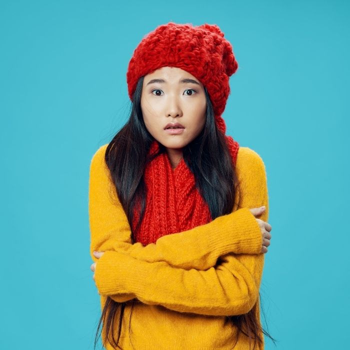 Mujer con suéter y bufanda, prueba de que las mujeres sienten más frío que los hombres.- Blog Hola Telcel