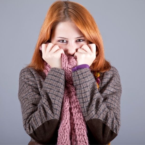 Mujer con suéter y bufanda, prueba de que las mujeres sienten más frío que los hombres.- Blog Hola Telcel 