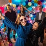 Two beautiful best friends dancing and having fun at party