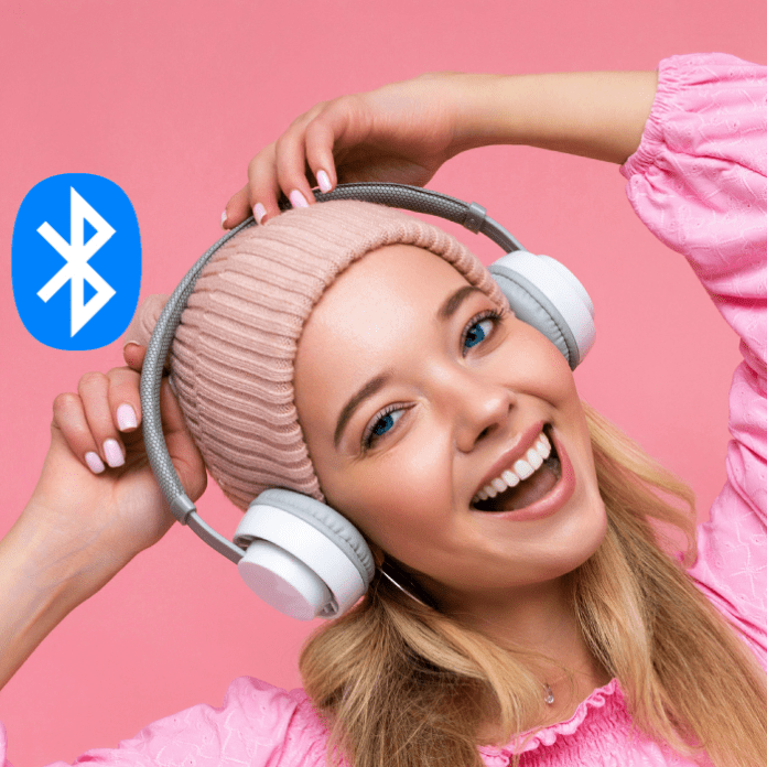 Mujer con audífonos sonriendo por la llegada de Auracast a diferentes dispositivos.- Blog Hola Telcel