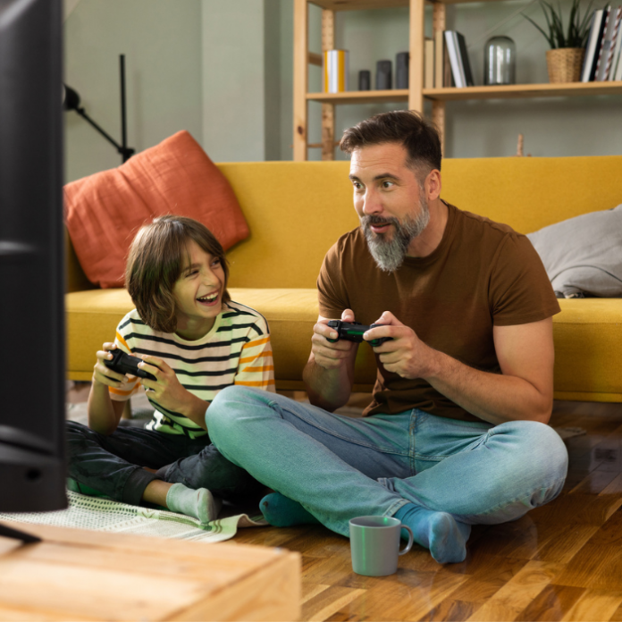 Padre e hijo jugando en PlayStation 5.- Blog Hola Telcel.